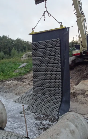 Hijsen van de betonblokkenmat met grasbeton tegels voor oeverversteviging