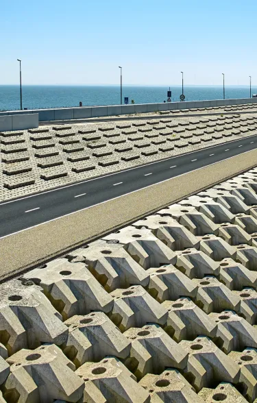 De afsluitdijk met de basalton quattroblock zuilen en Lely op de achtergrond en 