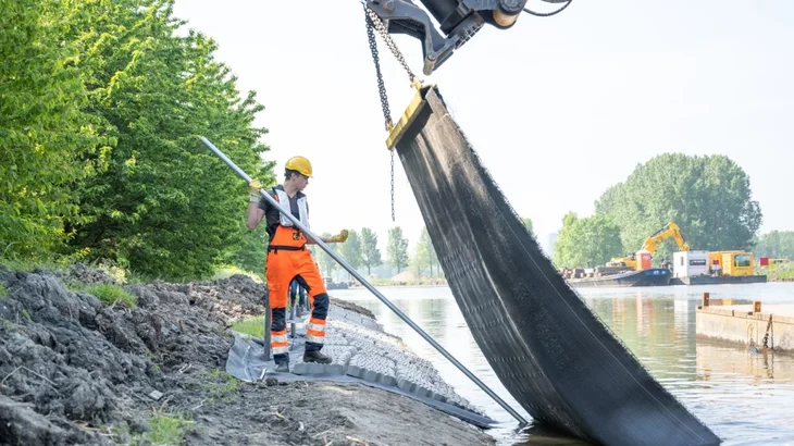 De blokkenmat wordt geplaatst voor oeverbescherming van de Hoge Vaart in Almere