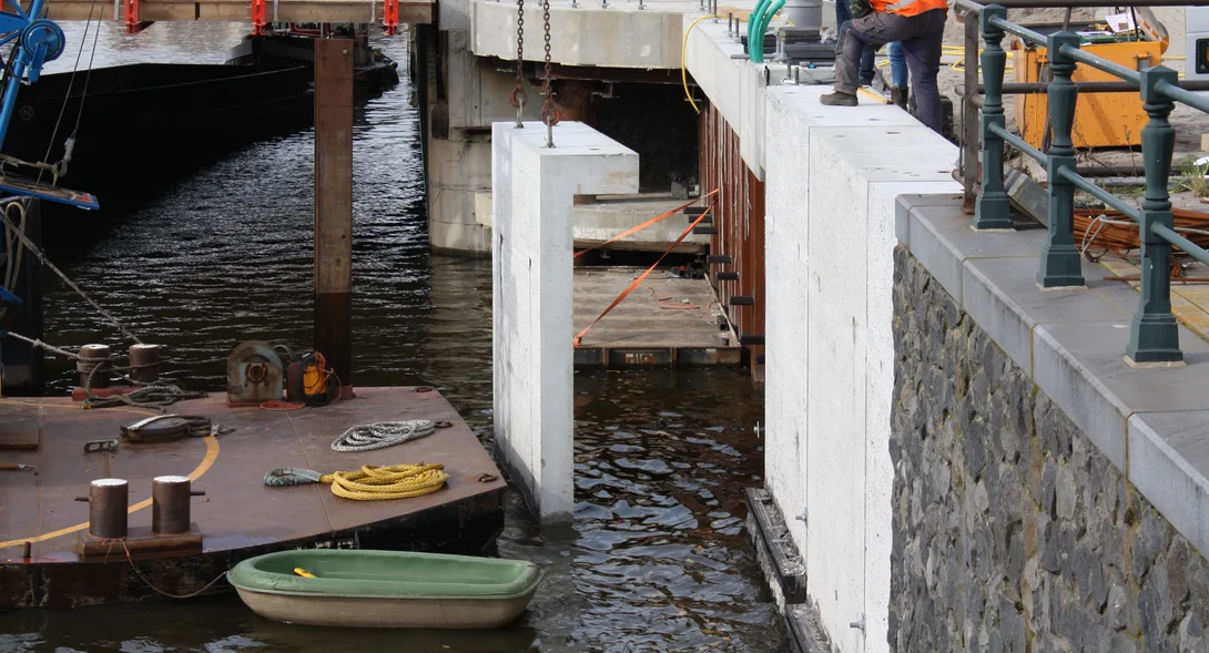 De prefab deksloven hangen in de kraan om op de damwand te plaatsen
