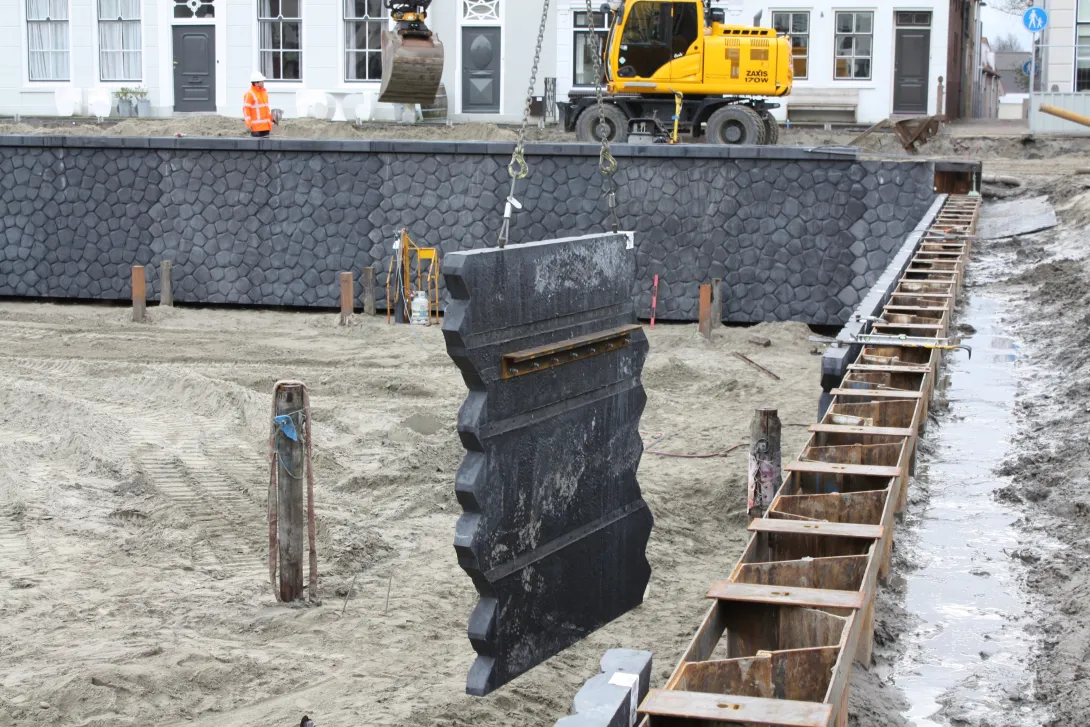 Prefab kademuur in de kraan in de haven van Brouwershaven