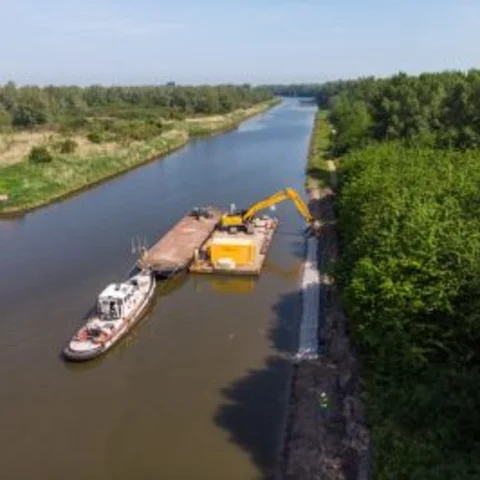 Luchtfoto van het plaatsen van de betonblokkenmatten (Betomat) met grasbetontegel aan de Hoge Vaart in Almere