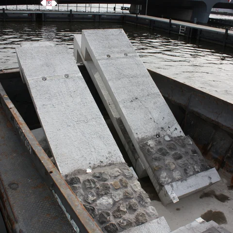 De prefab kademuren liggen klaar op het ponton te wachten om geplaatst te worden