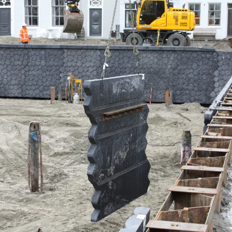 Prefab kademuur in de kraan in de haven van Brouwershaven