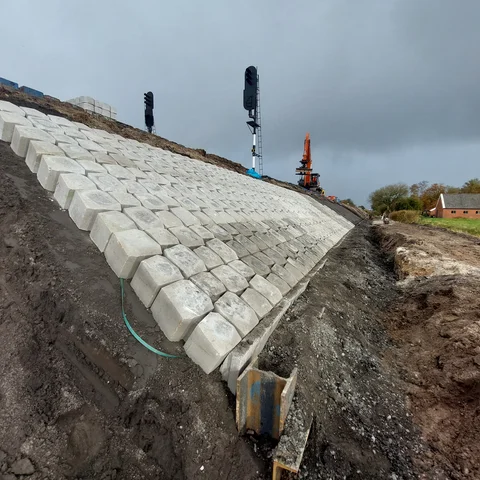 Basalton Quattroblock zuilen plaatsen tegen de glooiingsbanden op de Spoorbaan Sappermeer